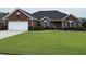 Charming one-story brick home with a well-manicured lawn and attached two-car garage at 3516 Queens Harbour Blvd., Myrtle Beach, SC 29588
