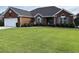 Beautiful one-story red brick home with blue shutters and a well-manicured front yard at 3516 Queens Harbour Blvd., Myrtle Beach, SC 29588