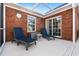 Comfortable outdoor seating featuring two lounge chairs on a screened patio with brick walls and a clear ceiling at 3516 Queens Harbour Blvd., Myrtle Beach, SC 29588