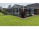 Exterior view of the screened-in pool, surrounded by brick-lined garden and green lawn at 3516 Queens Harbour Blvd., Myrtle Beach, SC 29588