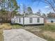 Charming one-story home with black and white exterior, a deck, and a concrete driveway at 3530 Reavis Ln., Myrtle Beach, SC 29579
