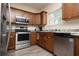 Well-lit kitchen with stainless steel appliances, wood cabinets, and durable vinyl flooring at 3952 Murrells Inlet Rd., Murrells Inlet, SC 29576