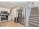 Modern kitchen featuring stainless steel appliances, a stylish backsplash, and convenient access to the staircase at 409 36Th Ave. N, North Myrtle Beach, SC 29582