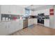 Bright kitchen featuring stainless steel appliances, white cabinets, and a stylish blue backsplash, ideal for cooking at 409 36Th Ave. N, North Myrtle Beach, SC 29582