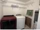 Functional laundry area features a red washer and white dryer with shelving for storage at 412 Olive St., Georgetown, SC 29440