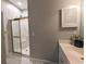 Bright bathroom features a glass-enclosed shower, modern vanity and white tile flooring at 4221 Hibiscus Dr. # 101, Little River, SC 29566