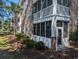 Back of a brick multi-Gathering home with screened porches and mature landscaping at 4221 Hibiscus Dr. # 101, Little River, SC 29566