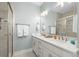 Well-lit bathroom with a double sink vanity, large mirror, and glass-enclosed shower at 436 E Third St., Ocean Isle Beach, NC 28469