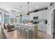 Modern kitchen with white cabinets, island with seating, and stylish pendant lighting in an open concept design at 436 E Third St., Ocean Isle Beach, NC 28469