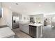 Modern kitchen features stainless steel appliances, gray cabinets, a spacious island, and an adjacent dining area at 4517 East Coast Ln., Shallotte, NC 28470