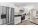 Close-up view of the kitchen's stainless steel refrigerator, oven, white cabinets, and beautiful granite countertops at 5026 Adrian Hwy., Conway, SC 29526