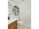 Well-lit half bathroom featuring modern fixtures, stylish round mirror, and floating shelves at 513 Hillside Dr. S, North Myrtle Beach, SC 29582
