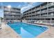 Inviting community pool with lounge chairs, surrounded by well-maintained condo buildings under a sunny sky at 627 North Waccamaw Dr. # 212, Murrells Inlet, SC 29576