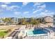 Inviting community pool area with lounge chairs, umbrellas, and lush tropical palm trees enhances vacation vibes at 627 North Waccamaw Dr. # 212, Murrells Inlet, SC 29576