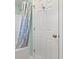 Well-lit bathroom features a shower with a patterned curtain and a white door at 633 White Oak Ln., North Myrtle Beach, SC 29582