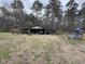 Exterior view of rustic outbuilding showing boat storage and play area in grassy yard at 657 Mulberry Rd., Salters, SC 29590