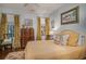 Cozy bedroom featuring wood floors, a patterned rug, a tan bedspread, and gold curtains at 762 Wraggs Ferry Rd., Georgetown, SC 29440