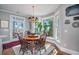 Charming dining room features a round wood table, chandelier, large windows, and stylish area rug at 762 Wraggs Ferry Rd., Georgetown, SC 29440