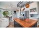 Close up view of a kitchen island with wood countertop and copper pot rack at 762 Wraggs Ferry Rd., Georgetown, SC 29440