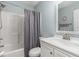 Bright bathroom featuring a shower-tub combo, gray shower curtain, white sink vanity and large mirror at 850 Fairway Dr. # 1003Ee, Longs, SC 29568