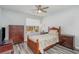 A comfortable bedroom with warm wood furniture, ceiling fan, and natural light for a relaxing space at 850 Fairway Dr. # 1003Ee, Longs, SC 29568