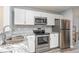 Modern kitchen featuring stainless steel appliances, granite countertops, and white cabinets at 850 Fairway Dr. # 1003Ee, Longs, SC 29568