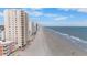 Aerial view of the beach, ocean, and condominiums on a sunny day at 900 N Waccamaw Dr. # 203, Garden City Beach, SC 29576