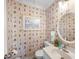 Nautical-themed half bath featuring wallpaper with sailboat motifs, a round mirror, and a sink at 900 N Waccamaw Dr. # 203, Garden City Beach, SC 29576