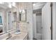 Well-lit bathroom with neutral wallpaper, a vanity sink, and a shower with a curtain at 900 N Waccamaw Dr. # 203, Garden City Beach, SC 29576