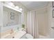 Bright bathroom featuring a tub with shower, vanity with sink and mirror, and coastal decor at 900 N Waccamaw Dr. # 203, Garden City Beach, SC 29576