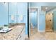 Light blue bathroom features a granite vanity and a separate room with a glass shower and toilet at 9100 Sw Fountain St., Calabash, NC 28467