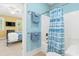 A full bathroom with a tub shower is visible from a bedroom with yellow walls and white trim at 9100 Sw Fountain St., Calabash, NC 28467