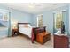 Light-blue bedroom with a queen bed, hardwood dresser, and two windows offering natural light at 9100 Sw Fountain St., Calabash, NC 28467