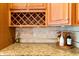 Close-up of granite countertop and stylish wood cabinet with a decorative wine rack at 9100 Sw Fountain St., Calabash, NC 28467