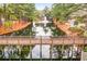 Scenic view of a bridge over a serene pond with a fountain and surrounding trees at 9100 Sw Fountain St., Calabash, NC 28467