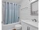 Bright bathroom featuring a tub with a shower and stylish plank walls at 9501 Shore Dr. # D-132, Myrtle Beach, SC 29572