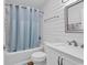 Bright bathroom featuring a tub with a shower and stylish plank walls at 9501 Shore Dr. # D-132, Myrtle Beach, SC 29572