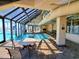 Indoor pool area with a glass ceiling, seating, and views of palm trees at 101 Ocean Creek Dr. # Mm-5, Myrtle Beach, SC 29572