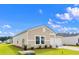 Charming single-story home features beige siding, a attached garage, and a well-maintained lawn under a bright blue sky at 108 Saddle St, Conway, SC 29527