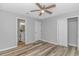 A well-lit bedroom featuring wood floors, a ceiling fan, an ensuite bathroom, and closet space at 110 Horizon River Dr. # I-2, Myrtle Beach, SC 29588