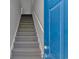Carpeted staircase with white railing adjacent to a blue front door, providing access to the upper level at 110 Horizon River Dr. # I-2, Myrtle Beach, SC 29588