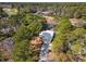 Aerial view of modern home with a metal roof, surrounded by lush greenery and backing onto a golf course at 144 Springfield Rd., Pawleys Island, SC 29585