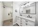 Bathroom featuring double sinks with black fixtures, marble countertops, and a tiled walk-in shower at 144 Springfield Rd., Pawleys Island, SC 29585