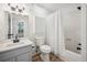 Bathroom featuring a gray vanity, new flooring, and a shower-tub combo with a white shower curtain at 144 Springfield Rd., Pawleys Island, SC 29585