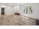 Sunlit living room featuring large windows, wood floors, and stairway with brick accents at 144 Springfield Rd., Pawleys Island, SC 29585