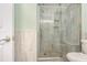 Walk-in shower in the updated bathroom featuring attractive tilework and seamless glass surround at 1581 S Waccamaw Dr. # 402, Garden City Beach, SC 29576