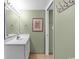 Bathroom featuring a single sink, large mirror, earth-toned walls, and adjacent doorway at 1706 S Ocean Blvd. # 1001, North Myrtle Beach, SC 29582
