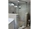 Modern walk-in shower with a glass door, pebble floor, and decorative tiled walls at 1706 S Ocean Blvd. # 1001, North Myrtle Beach, SC 29582