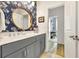 Modern bathroom with a round mirror, decorative wallpaper and gray cabinets at 2005 Silver Island Way, Murrells Inlet, SC 29576