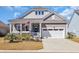 Charming home featuring a covered porch with American flag, and an attached garage with white door at 2005 Silver Island Way, Murrells Inlet, SC 29576